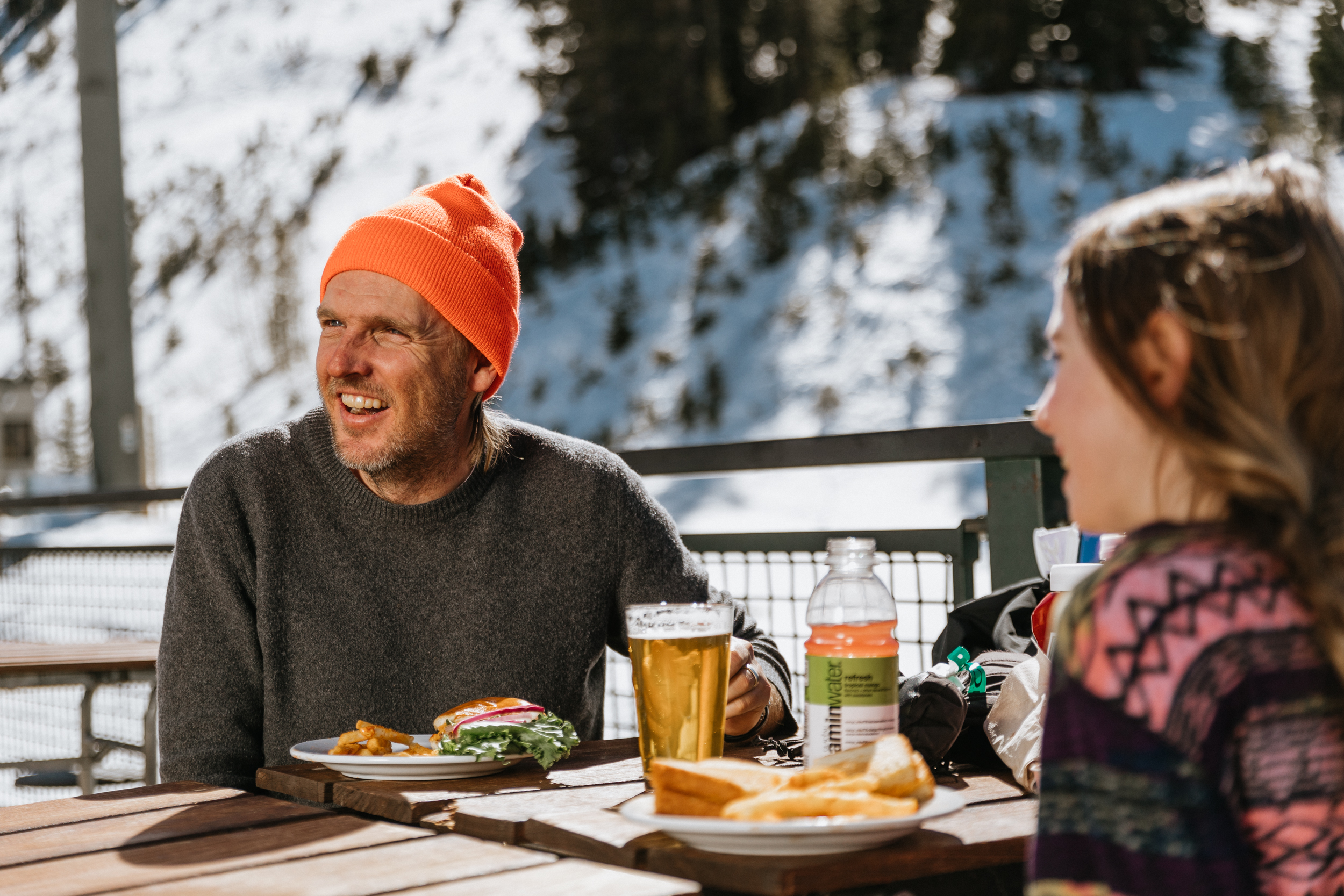 Two people enjoying food outdoors in the snowy mountains